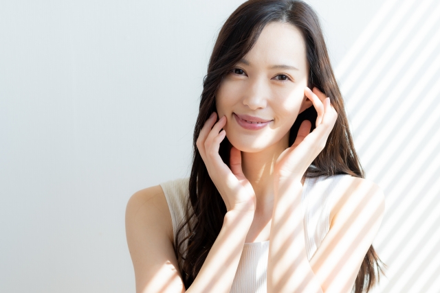 顔の横に手を添える女性