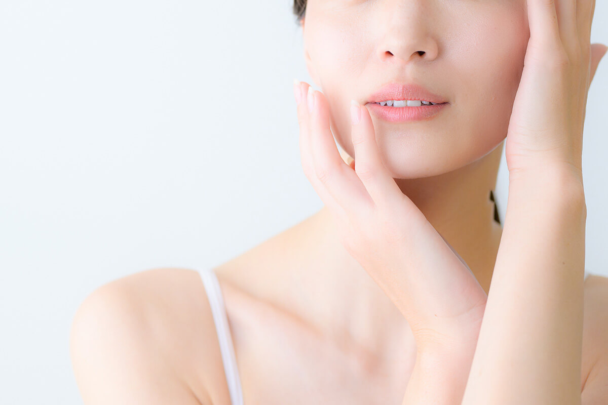 顔に両手を添える女性